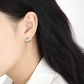 Pendientes de aro minimalistas de acero de titanio plata cepillada mostrados en el modelo - Color Acero
