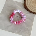 Pink and white marble print satin scrunchie shown on a decorative paper background - Gradient Pink