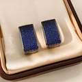 Detail van donkerblauwe micro-pave rechthoekige oorringen in een luxe sieradendoosje - Vierkant / Gunmetal Blauw