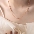 Golden titanium evil eye necklace featuring orange and white beads on model neck - Orange Necklace
