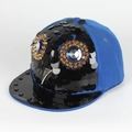 Dettaglio della toppa a gufo con paillettes, punte dorate e borchie su cappello hip-hop blu - Regolabile / Blu