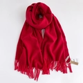 Dettaglio di una sciarpa rossa effetto cashmere con frange morbide ed etichetta del marchio - Rosso Vino