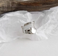 Detailansicht eines silbernen konkaven Rings auf texturiertem Hintergrund - Bogen Konkav/Verstellbar Offen / Silber
