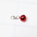 Detail of a bright red metal bell pendant with a silver lobster clasp on white background - Glossy Red