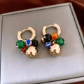 Macro detail of gold hoop earrings with multi-colored stone beads and a polished gold sphere - Gold Geometric Beaded