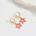 Dettaglio di orecchini a stella rosa con strass colorati su pietra di marmo bianco - Stile Stella Rosa (ES2639)