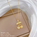 Detail van gouden kersenketting met strassteentjes op zijde in een sieradendoos - Gouden Kers Hanger (D443)