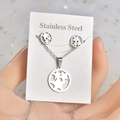 Detailed view of silver stainless steel star necklace and earrings set on display card - Circular Star