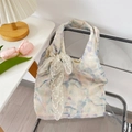 Detail of floral embroidery and lace ribbon on a soft watercolor bow tote bag - Blue with Apricot Flower