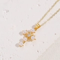 Collana a croce dorata con perla e zircone centrale su superficie bianca testurizzata - Croce Perla Oro (Placcato Oro 14K)
