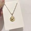 Dettaglio del ciondolo a cuore dorato con finitura testurizzata e catena a maglie - DN064 Disco a Cuore / Oro