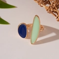 Gedetailleerde opname van een vergulde open ring met donkerblauwe en mintgroene emaille - Onregelmatige Geometrische Stijl / Donkerblauw en Muntgroen Contrast