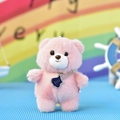 Detailed view of a cute pink plush teddy bear keychain pendant with a guitar accessory. - Ball Chain / Pink