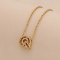 Macro shot of gold letter Q pendant necklace with sparkling cubic zirconia on O-chain - Letter Q
