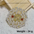 Gold round brooch with pearls, red gemstones and pavé crystals on a white knit - Gold Round Pearl