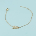 Detalle de una pulsera dorada de acero inoxidable con colgante Love sobre fondo azul - Pulsera de Oro