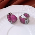 Macro shot of asymmetric drop earrings with pink zircon pavé on gunmetal finish - Purple/Pink