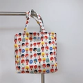 Dettaglio di una borsa in cotone con stampe di cartoni colorati ed etichetta tessuta - Bambino bambina