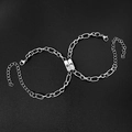 Detail van zilveren zon- en maanbedeltjes op roestvrijstalen schakelarmbanden - Roestvrijstalen Drievoudig Gespleten Zon Maan Paar