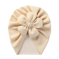 Detailed close-up of a beige turban hat featuring a large flower with a pearl and crystal center - Beige