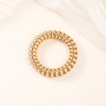 Detail of high-elasticity golden spiral hair coil on white silk fabric background - Metallic Gold (5cm Thick)