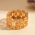 Makroaufnahme des goldenen breiten Armbands mit quadratischen Gliedern und Spiralmuster - Gold