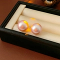 Macro shot of elegant pink-purple round pearl earrings inside a black jewelry box - 16mm / Pink