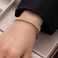 Detail shot of a gold tennis bracelet featuring rectangular white zircons on a wrist - Gold Large Rectangle