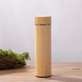 Bamboo vacuum thermos with stainless steel liner in natural wood finish on a rustic base - 500ml Cup with Full Bamboo Lid