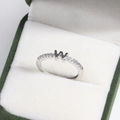 Macro view of adjustable silver letter W ring with small diamonds in a velvet box - Platinum W