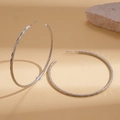 Detailaufnahme großer matter Creolen in Silber mit feiner Glitzer-Textur-Oberfläche - Silber