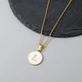 Detail of 18K gold necklace with a round white shell pendant and letter L engraving - Letter L Style / Gold