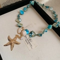 Detail of beach style necklace featuring blue turquoise beads, starfish and shells - Necklace-Blue