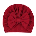 Detailed texture of burgundy ribbed knit baby hat with a large decorative bow - Burgundy