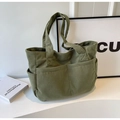 Dettaglio della borsa tote in velluto a coste verde con texture e doppie tasche - Verde