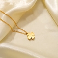 Macro view of gold four-leaf clover pendant necklace on luxury satin fabric - Gold