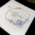 Macro detail of silver four-leaf clover bracelet with zircon inlay and mother of pearl - Hollow Flower Clover Style / Silver (White Clover)
