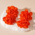 Detail view of handcrafted bright orange fabric flower earrings on white stone texture - Orange Flower (Silver Pin)