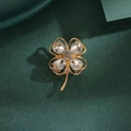 Elegant gold four-leaf clover brooch featuring pear-shaped crystals on dark green texture - 390# Four-leaf Clover