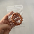 Brown carved bead bracelet presented in a transparent PVC self-sealing jewelry storage bag - 25 Micron 9x13cm Perforated Resealable / 100 Pcs/Pack