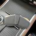 Portable dark grey leather eyewear pouch on car console showing sleek pebble grain texture - Black