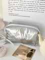 Nahaufnahme der silbernen gesteppten Kosmetiktasche mit Schmetterlingsmuster und Herzanhänger - Mit Anhänger / Silber