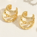 Dettaglio macro di un earcuff dorato multistrato con zirconi e intagli geometrici - Clip per orecchie a tre strati / Oro 14K