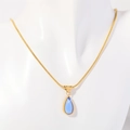 18K vergulde slangenketting met een blauwe druppelvormige hanger op een paspop - Maart
