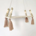 Nordisches Wandregal aus Holz mit rosa Perlen und weichen Quasten für Deko - Khaki