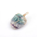 Detailed close-up of handmade gold wire-wrapped natural green and purple fluorite pendant - Purple Green Fluorite