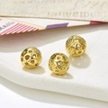 Macro shot of three hollow golden round beads for DIY jewelry with vintage mail backdrop - Style 7