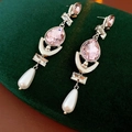 Gedetailleerde close-up van roze kristallen oorbellen met witte druppelparels vintage - Zilver Roze