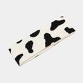 Primer plano de la suave diadema de punto con estampado de vaca en blanco y negro - Vaca