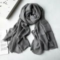 Gray modal scarf with fine stripe texture and fringe tassels on white wood background - Gray